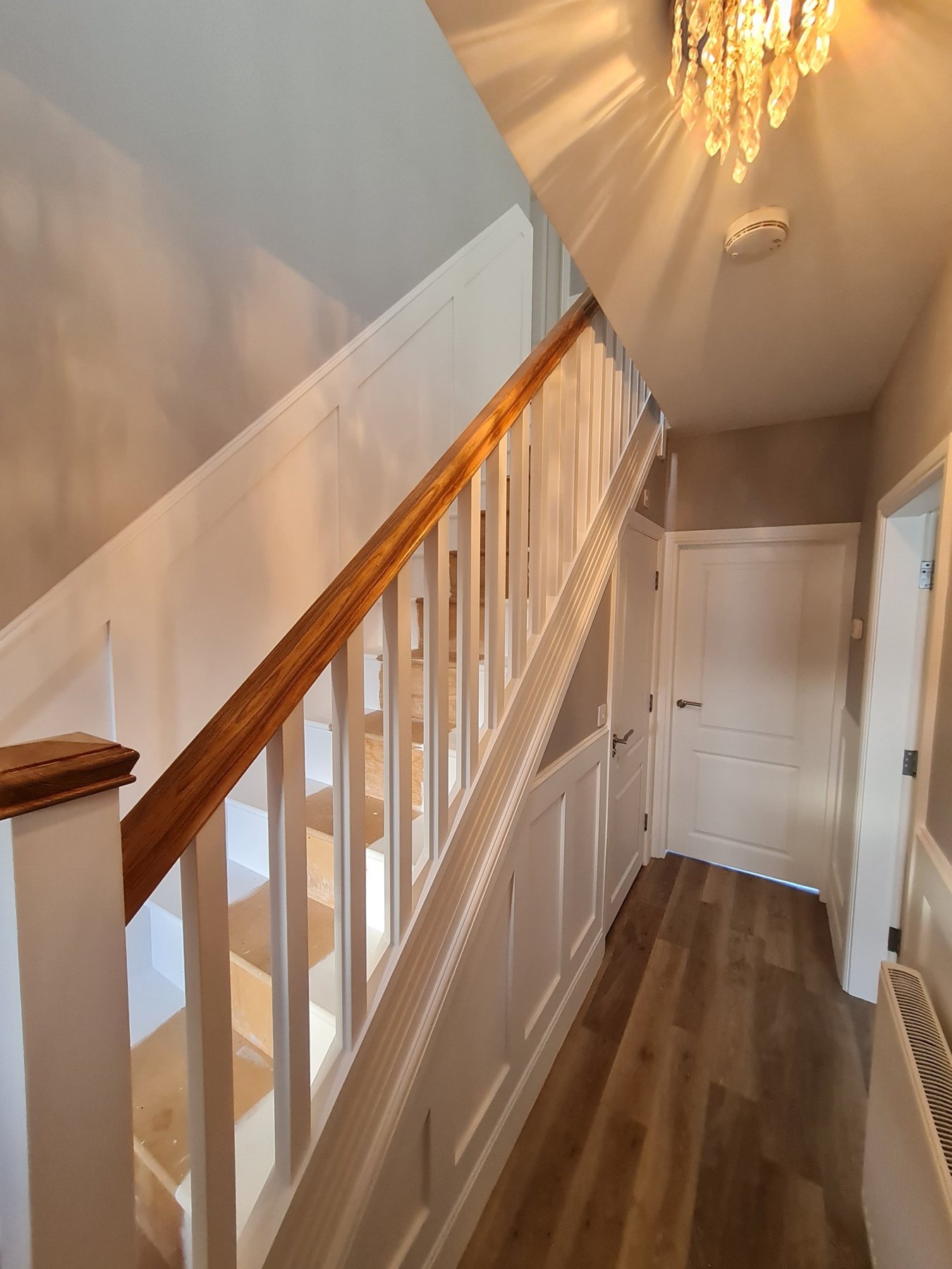 Finished staircase, banister and panelled hallway painted in white and grey, Abergele