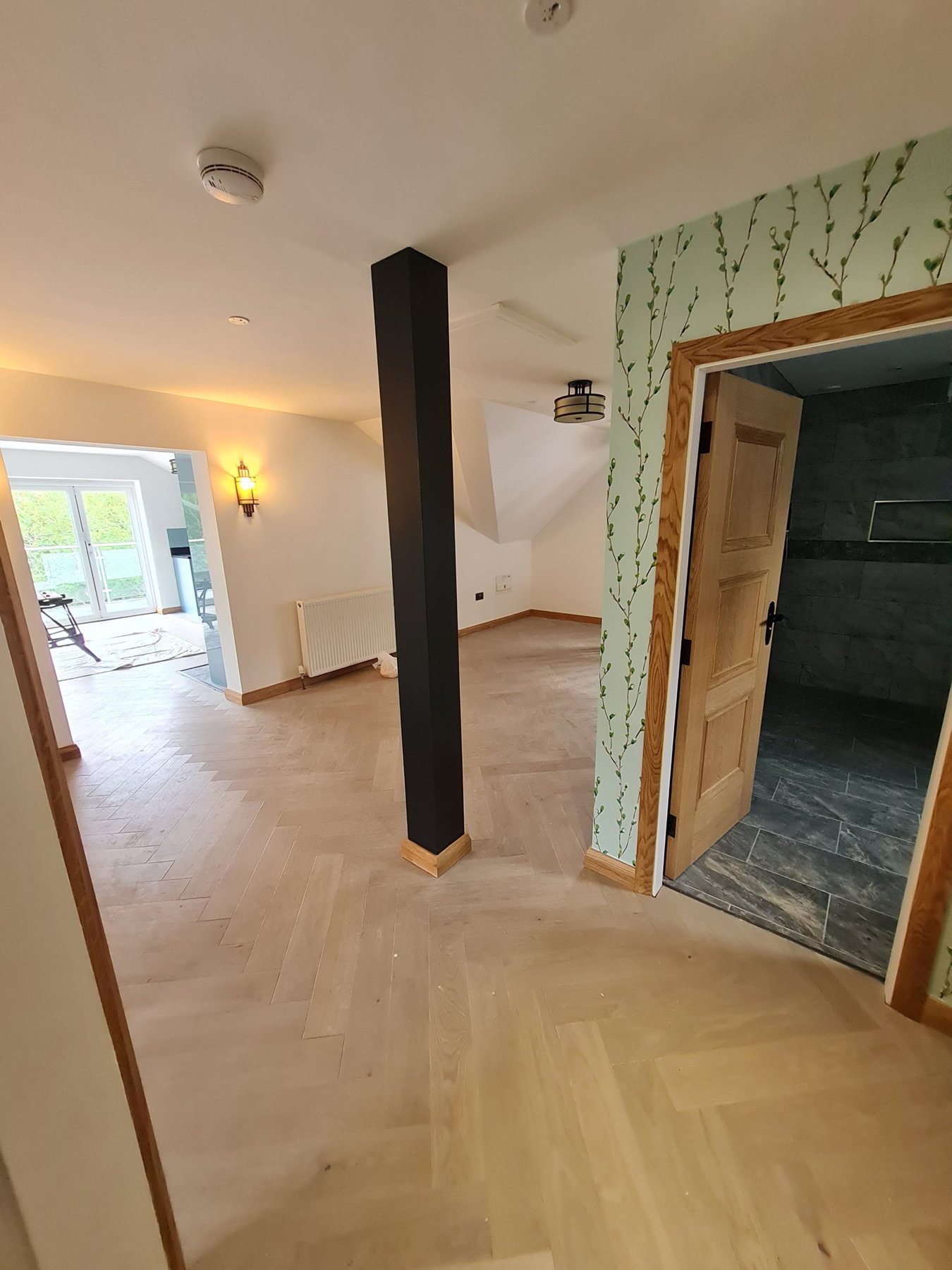 Dark painted column and willow wallpaper beside bathroom door on landing, Conwy annexe