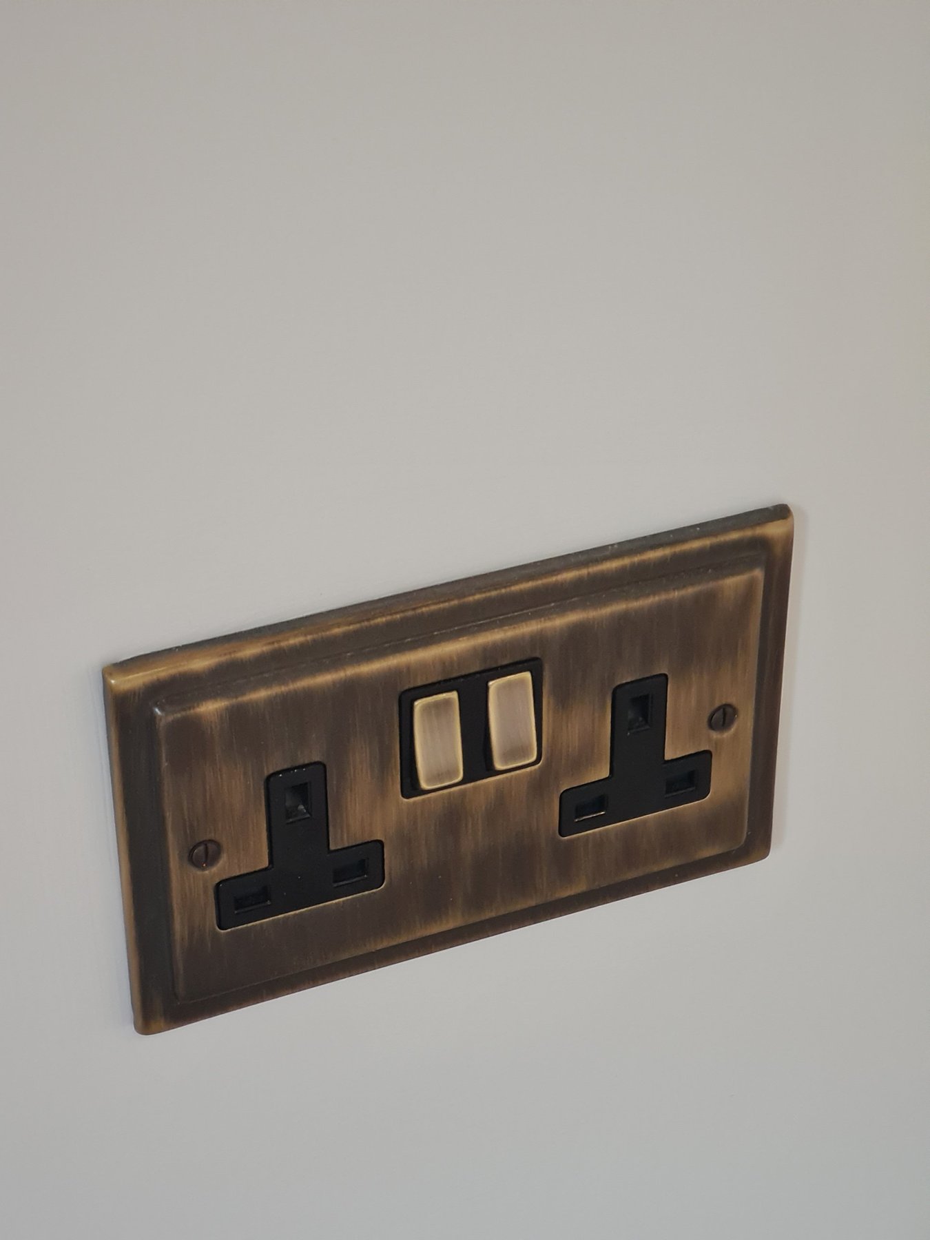 Antique brass socket on neatly painted wall, annexe in Conwy