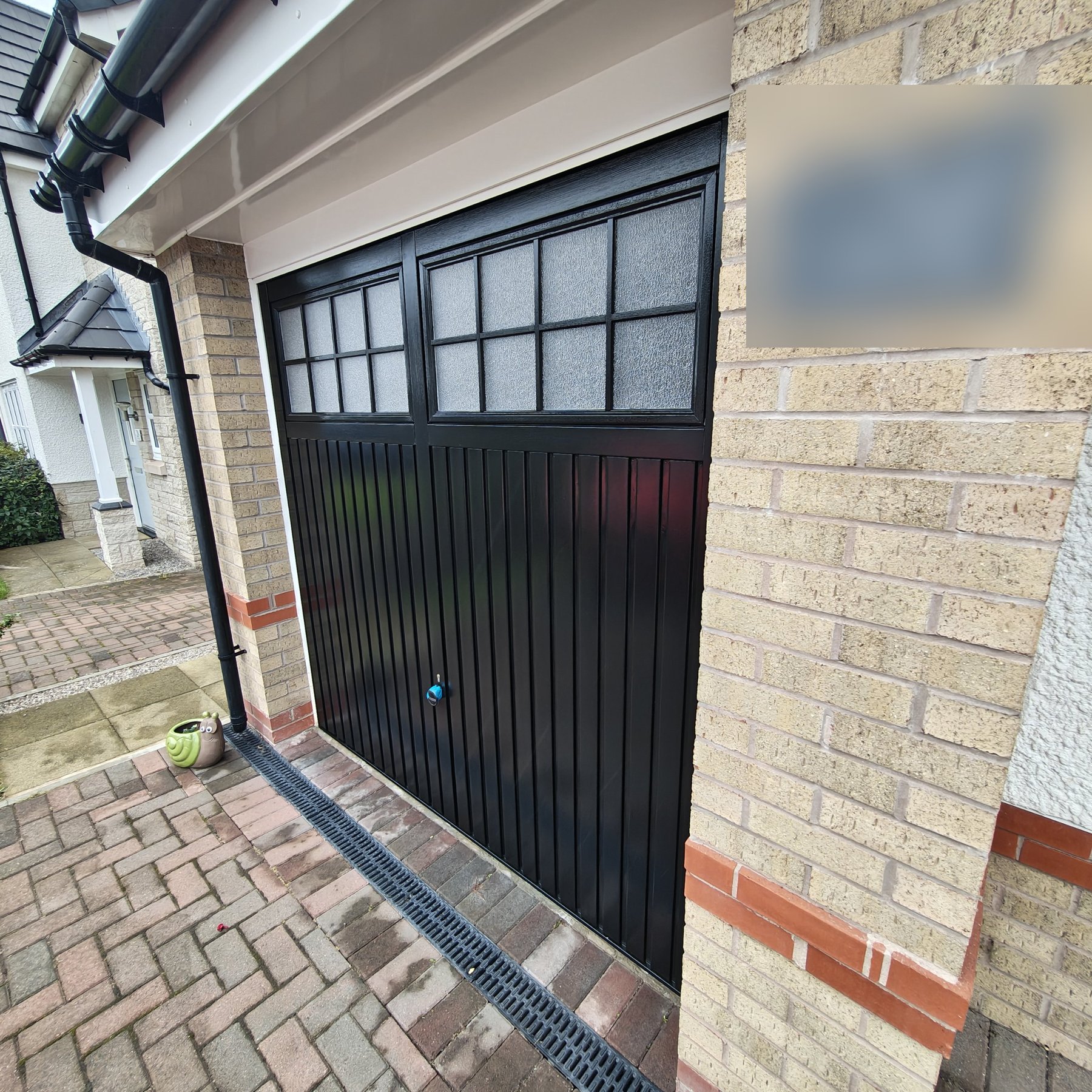 Painted black garage door panels and glazing, professional finish
