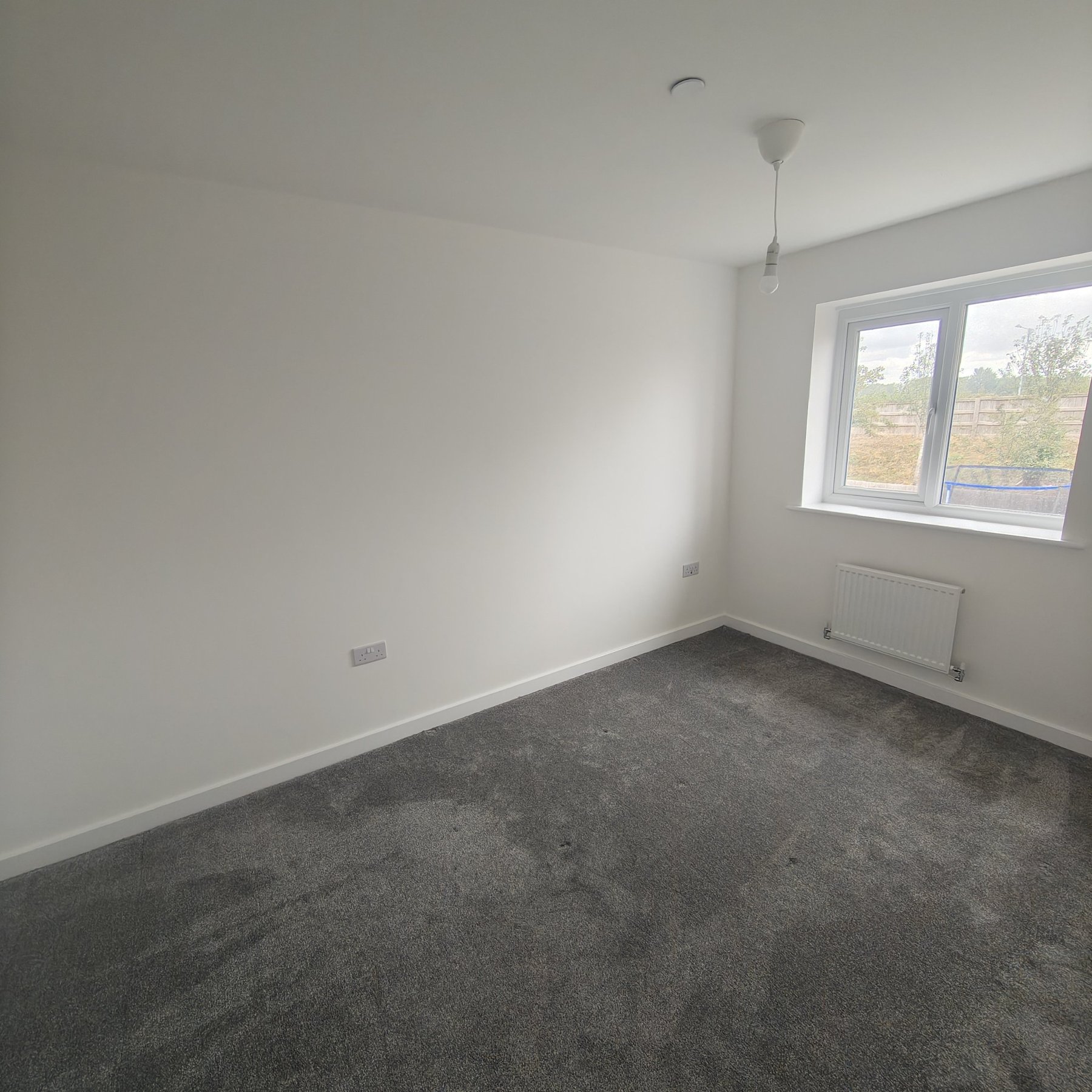 Repainted bedroom with white walls and ceiling, housing association void decorating, North Wales
