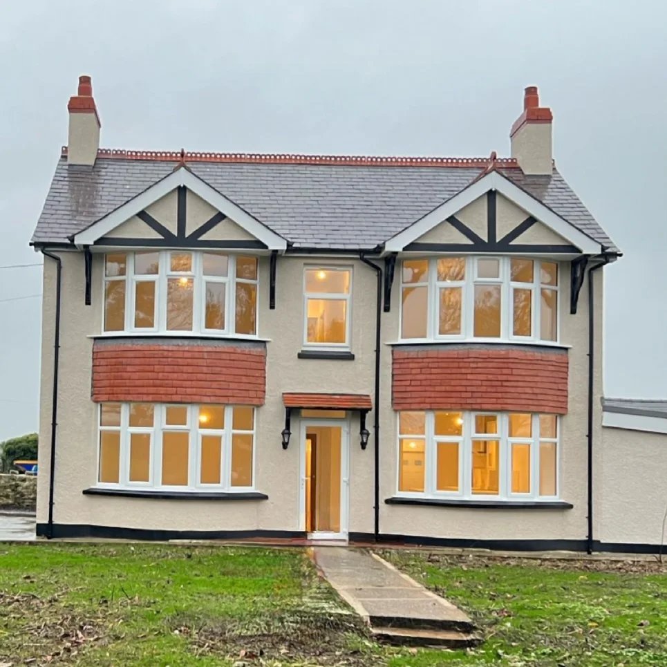 Farmhouse Interior and Exterior Painting in Llangefni, Anglesey Front of Llangefni farmhouse with painted bay windows, black gutters and render