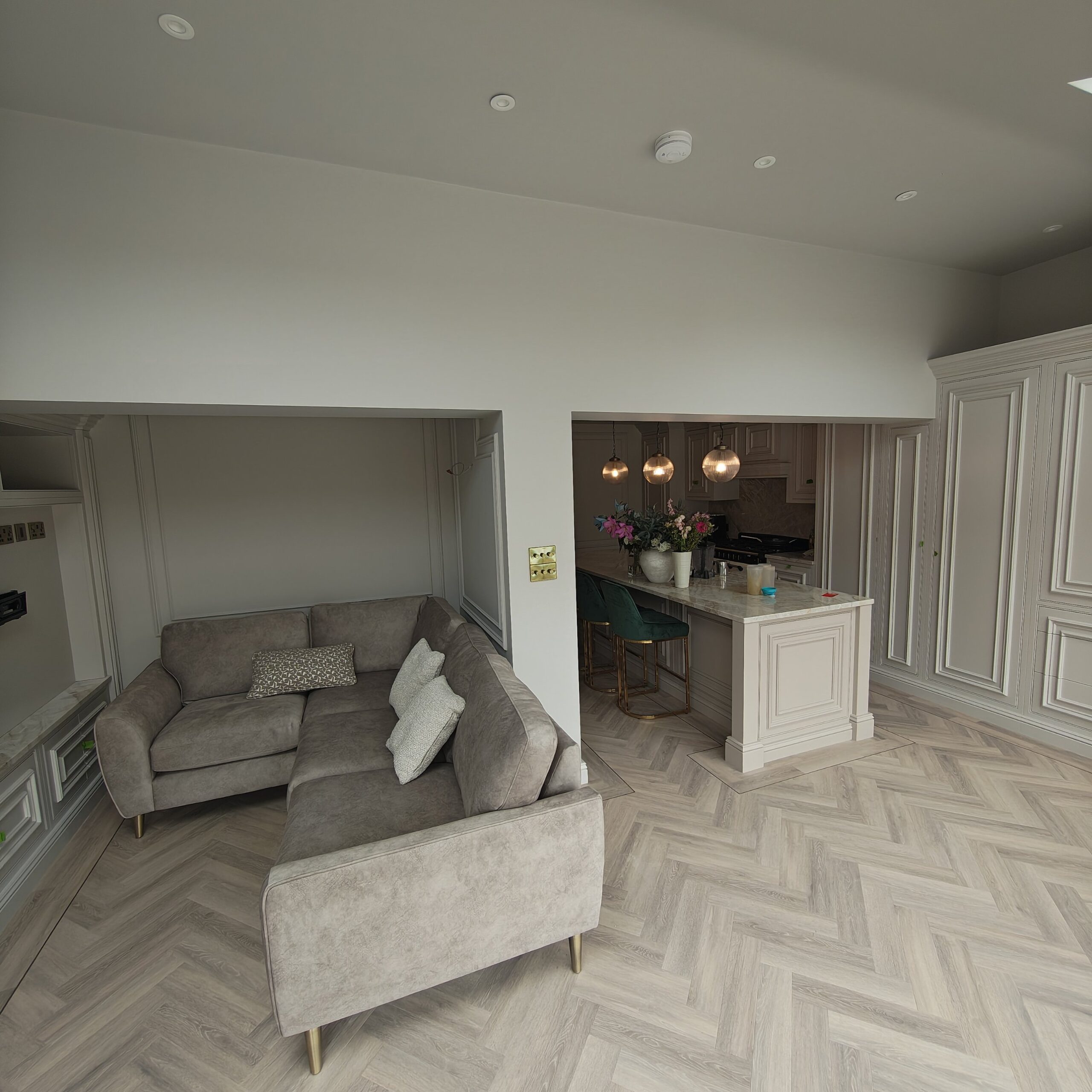 Kitchen diner in Conwy decorated by Voss Decorators - painted panelling and walls with sofa area and kitchen island