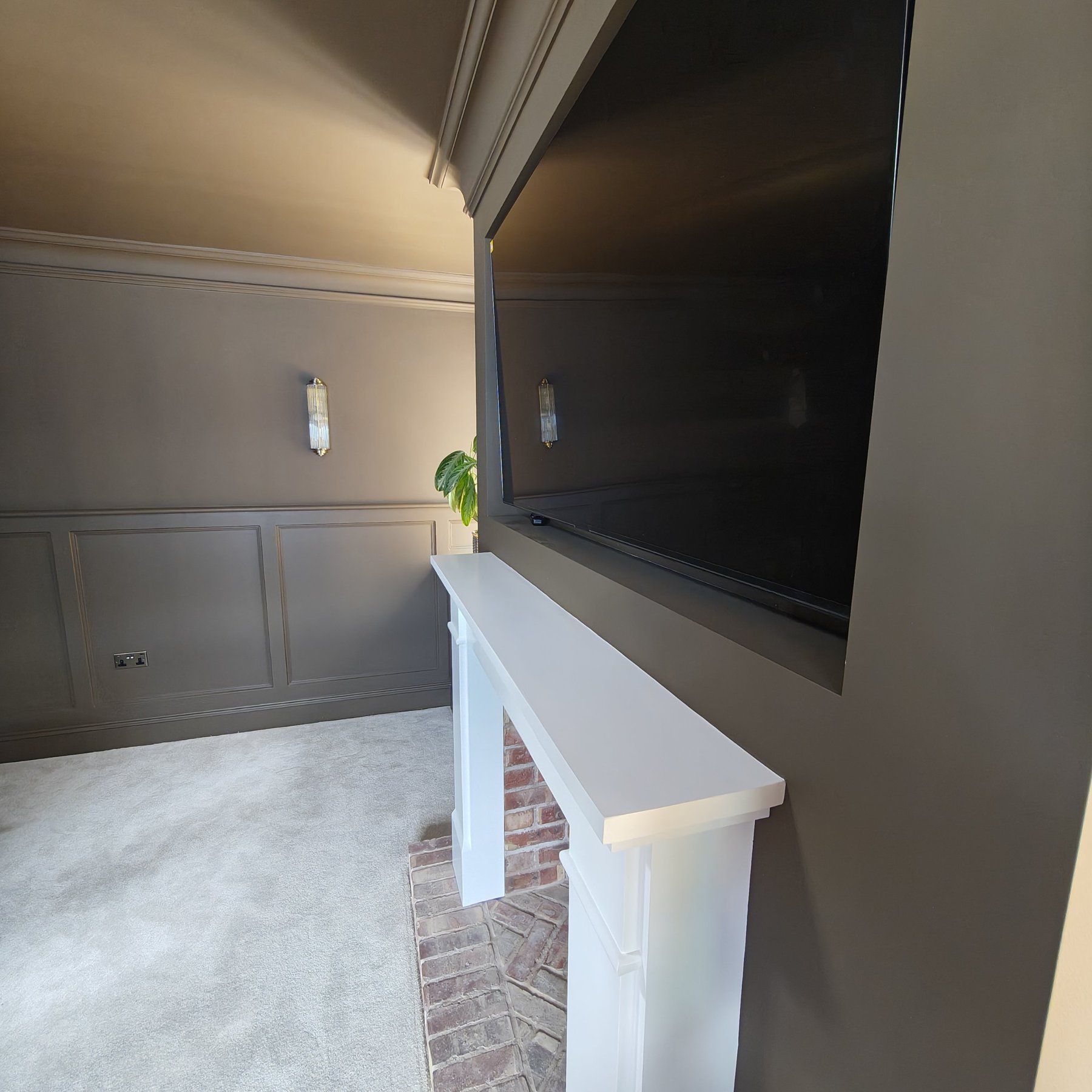 Painted chimney breast with TV recess and white fireplace surround, Penrhyn Bay