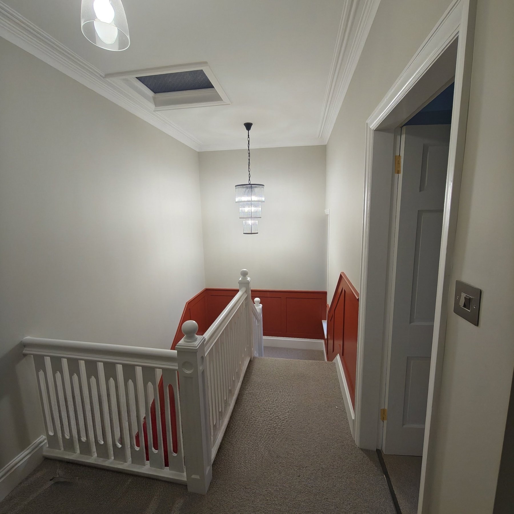 Finished landing with white banister, terracotta panelling and chandelier, Rhos on Sea