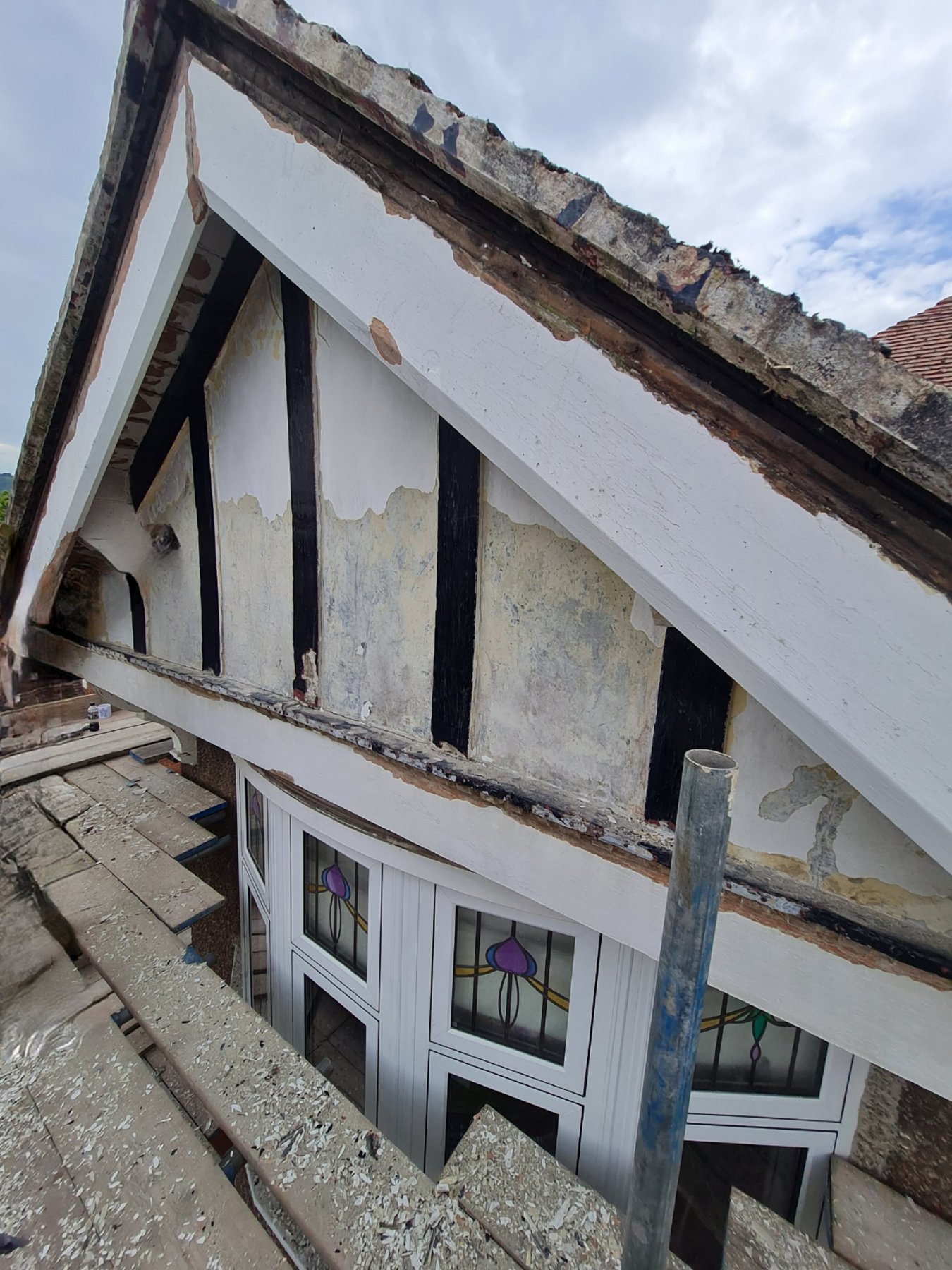 Peeling paint on the timber gable before preparation, Rhos on Sea