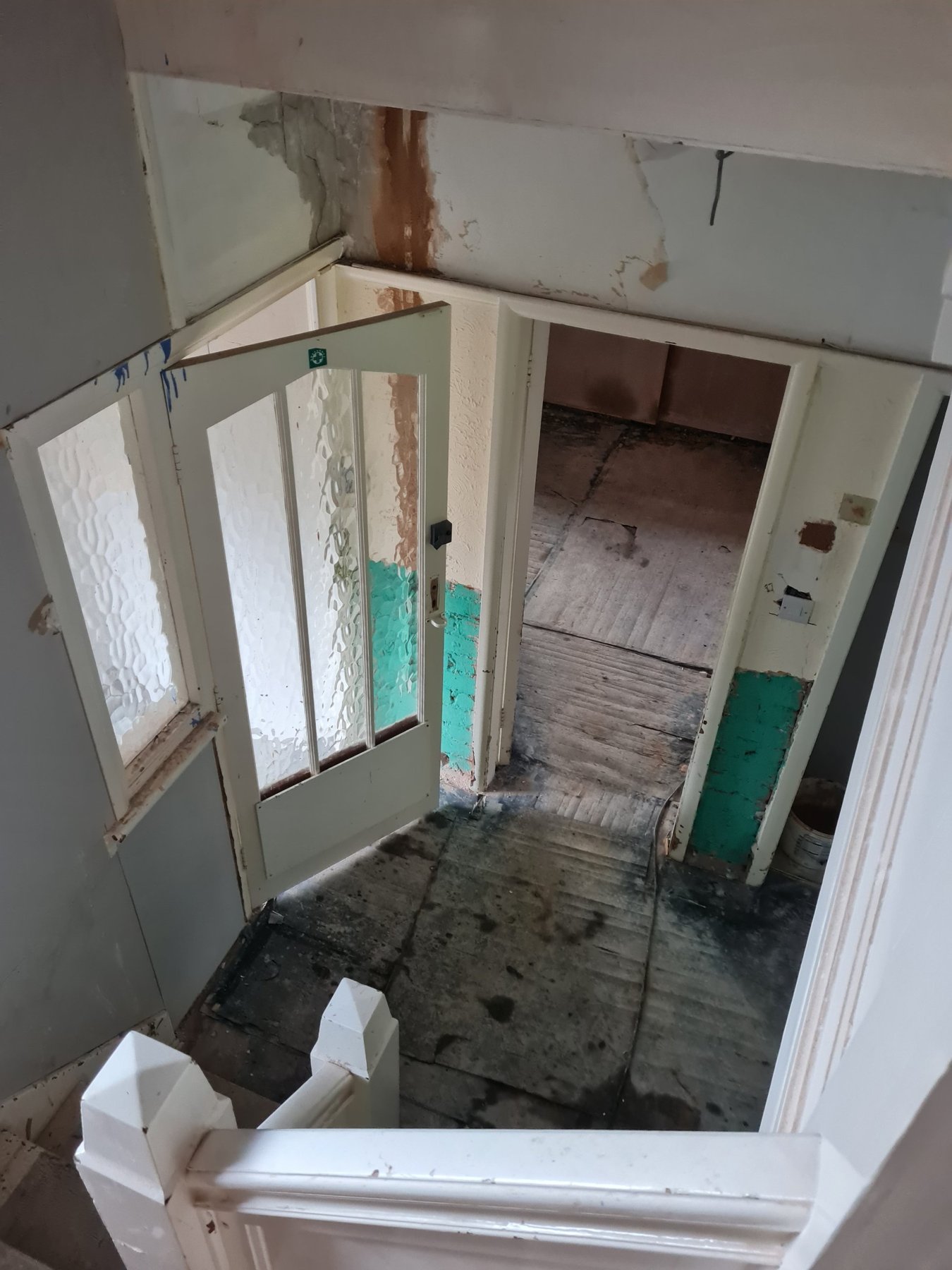 Stairs and old glazed door with damaged paintwork before redecorating, Rhyl