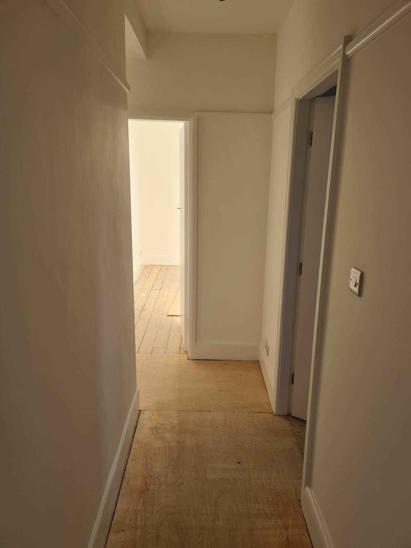 Hallway with painted walls, skirting boards and white doors, Rhyl