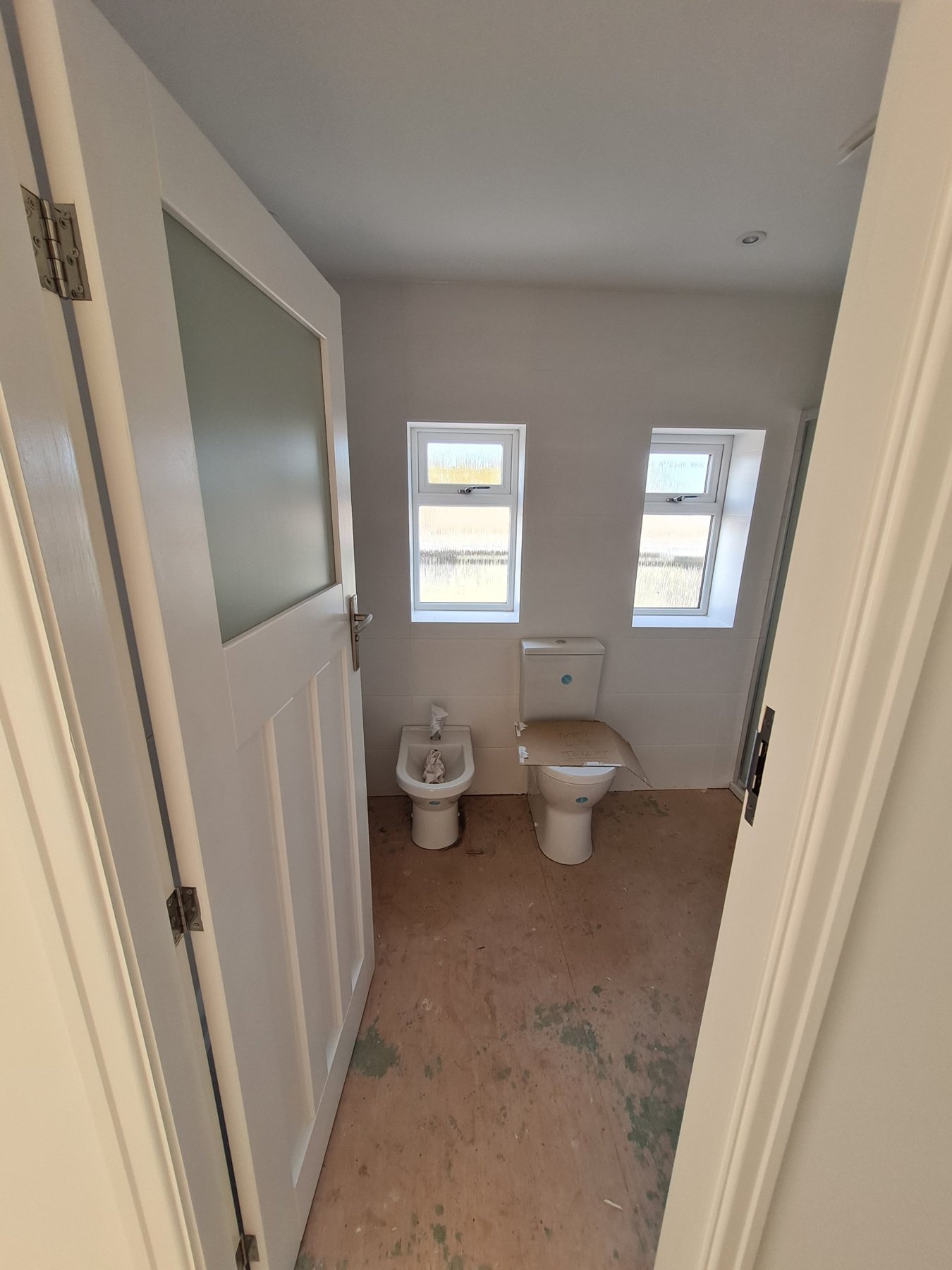 WC with freshly painted walls and white door, Rhyl